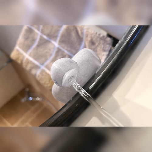 Marble-white duck faucet extender with water flowing from the beak