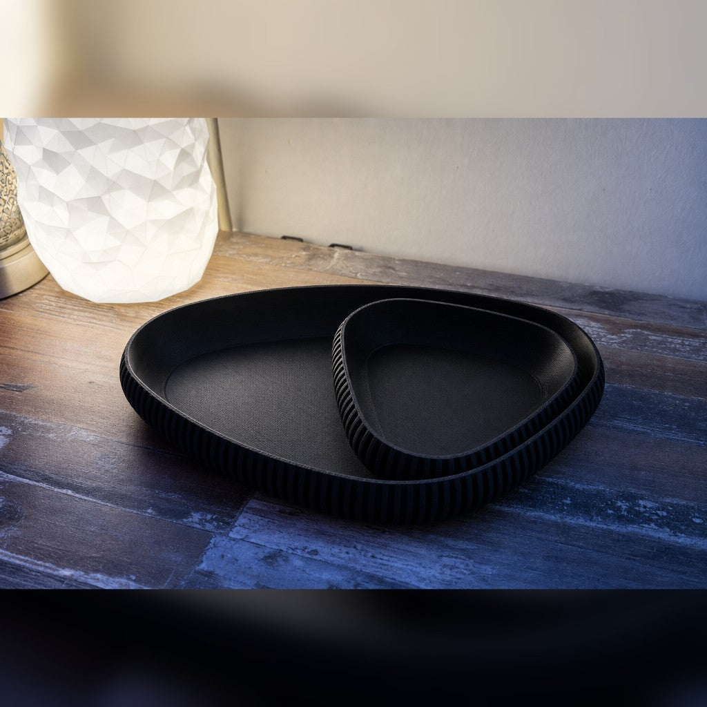 Nesting ribbed trays in black on a warm wood table