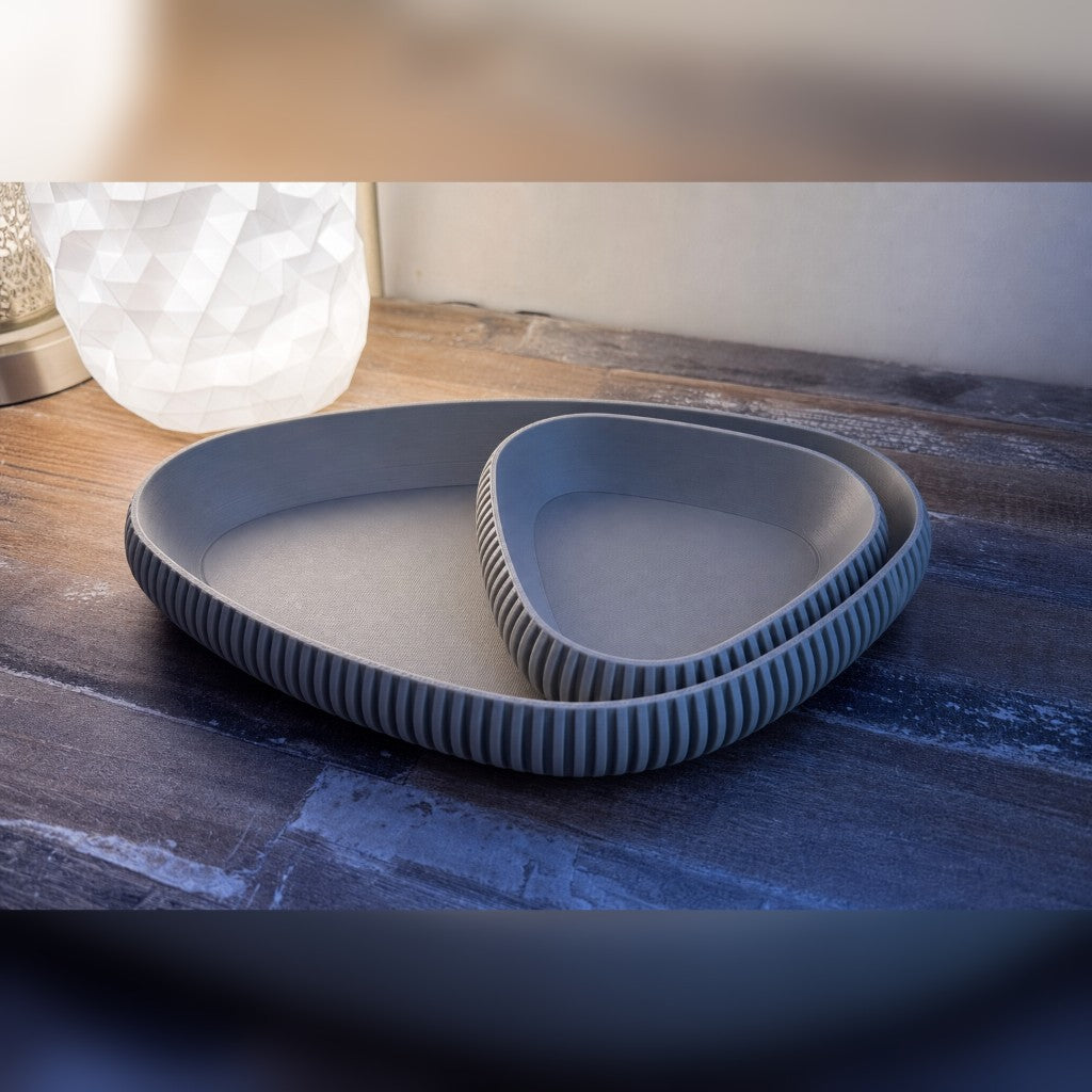 Nesting ribbed trays in gray on a warm wood table
