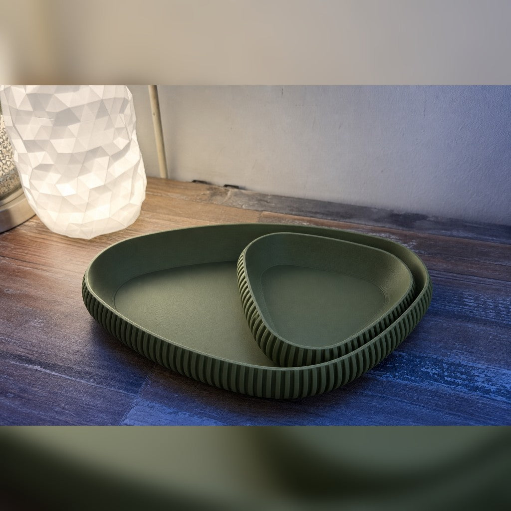 Nesting ribbed trays in olive green on a warm wood table