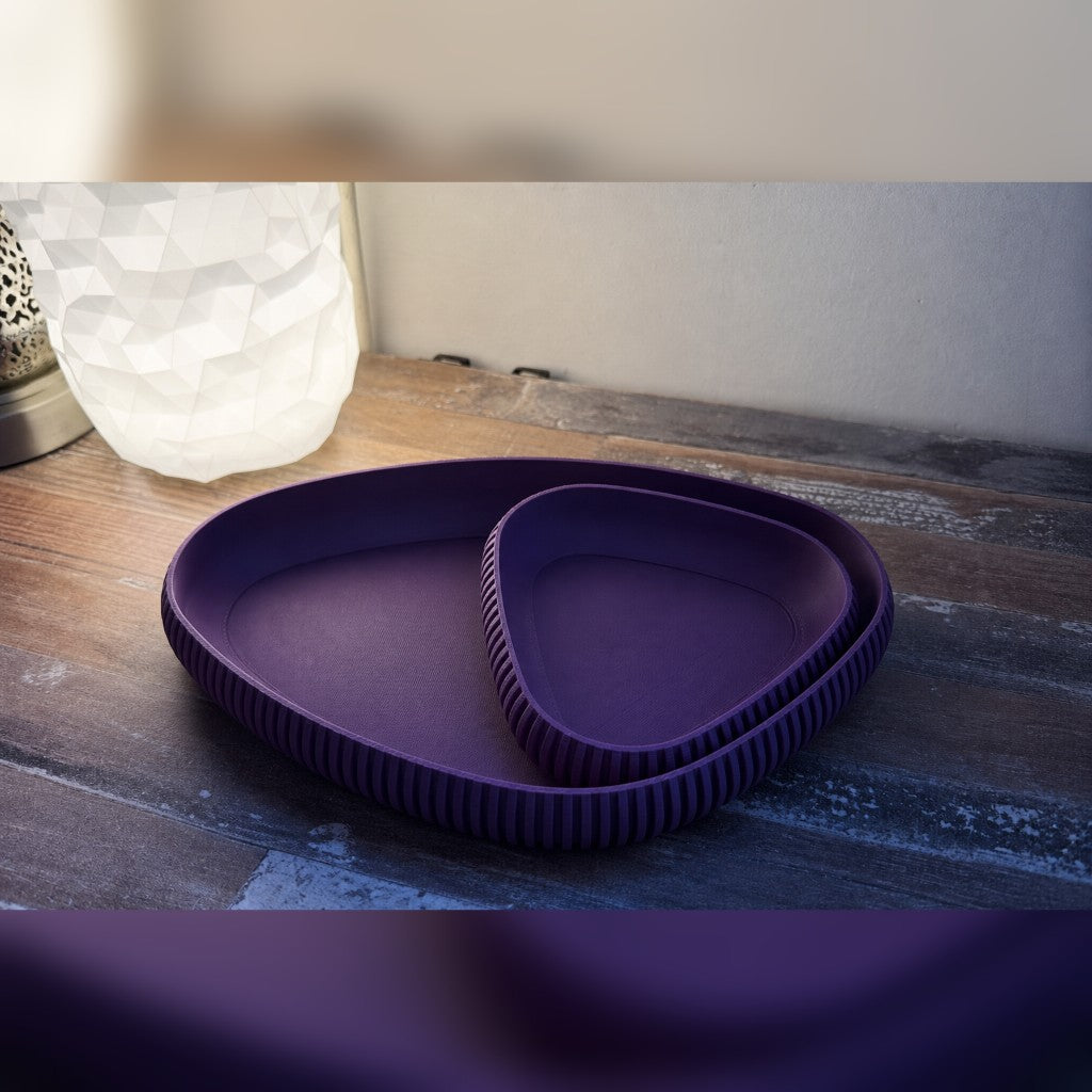 Nesting ribbed trays in violet on a warm wood table